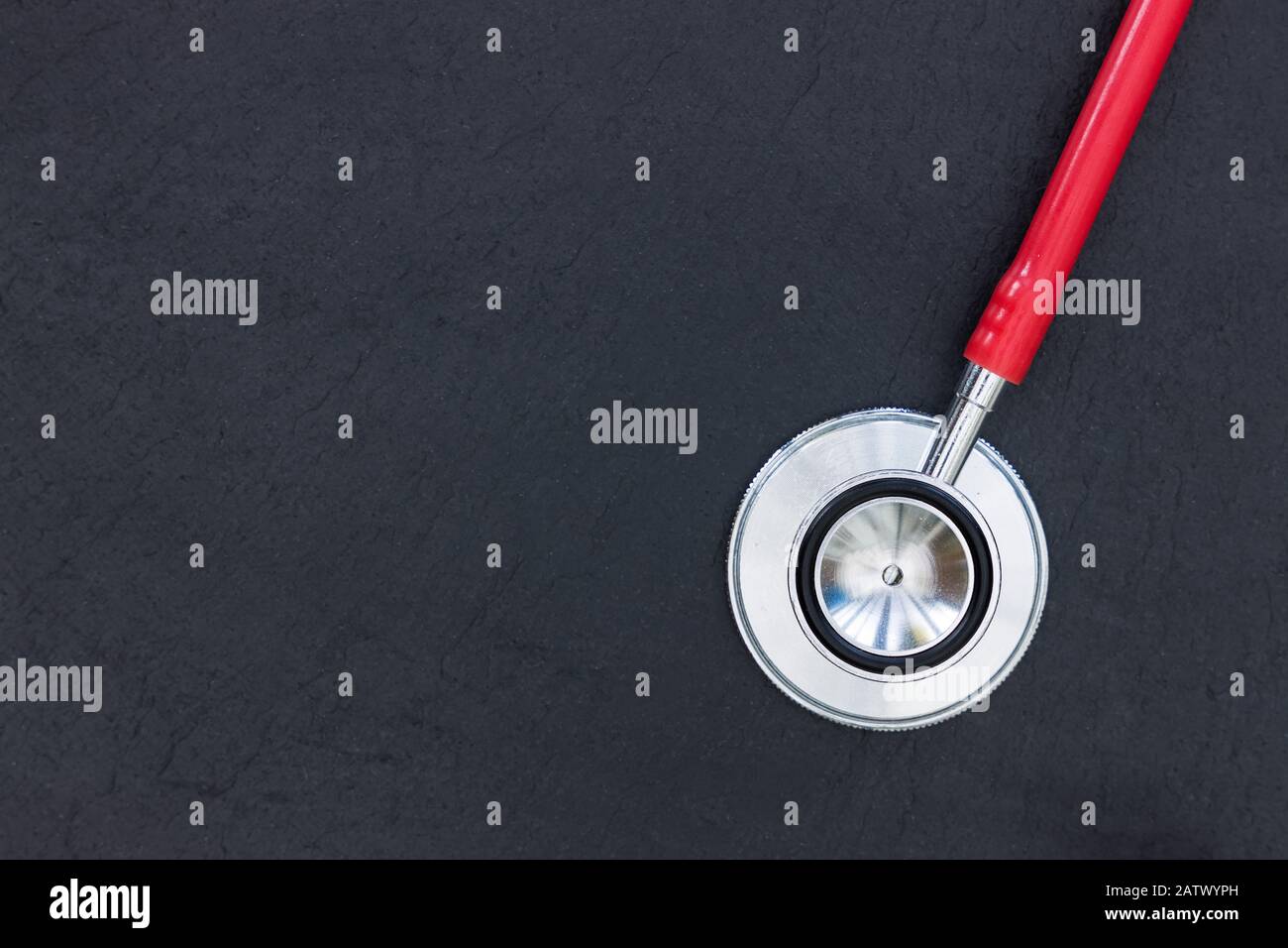Rotes Stethoskop auf dunklem Hintergrund Draufsicht minimales Konzept für die Gesundheit von Ärzten Stockfoto