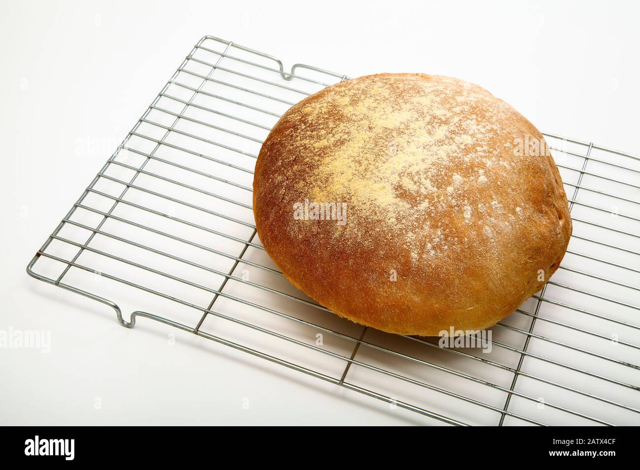 Frisch gebackenes Brotlaib auf einem Kühlregal, isoliert auf weißem Hintergrund Stockfoto