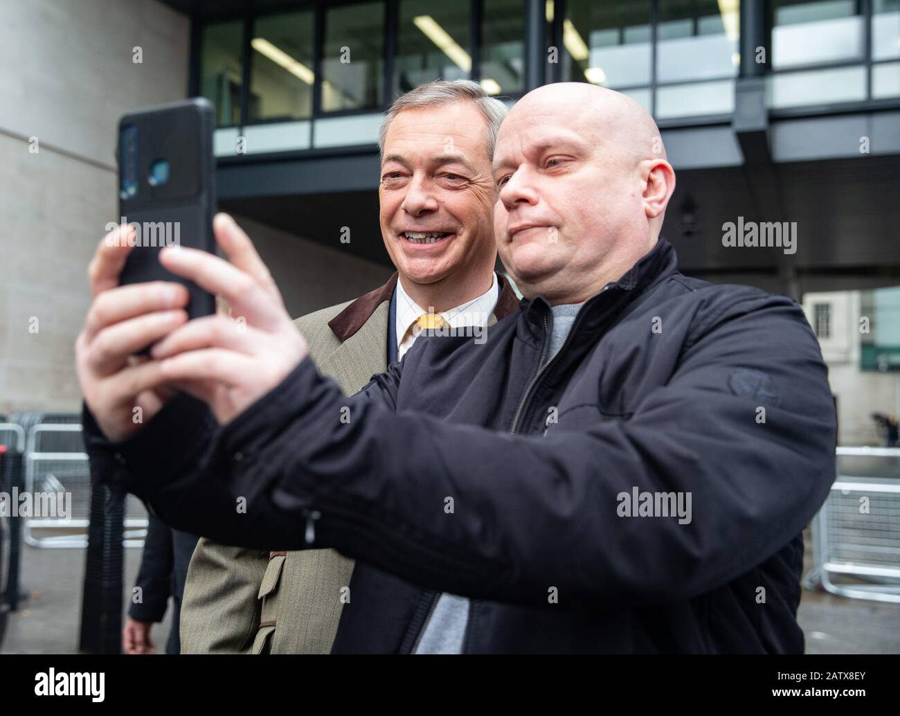 Der Parteiführer von Brexit, Nigel Farage, kommt in den BBC Studios an und posiert mit einem Unterstützer für eine "elfie". Stockfoto