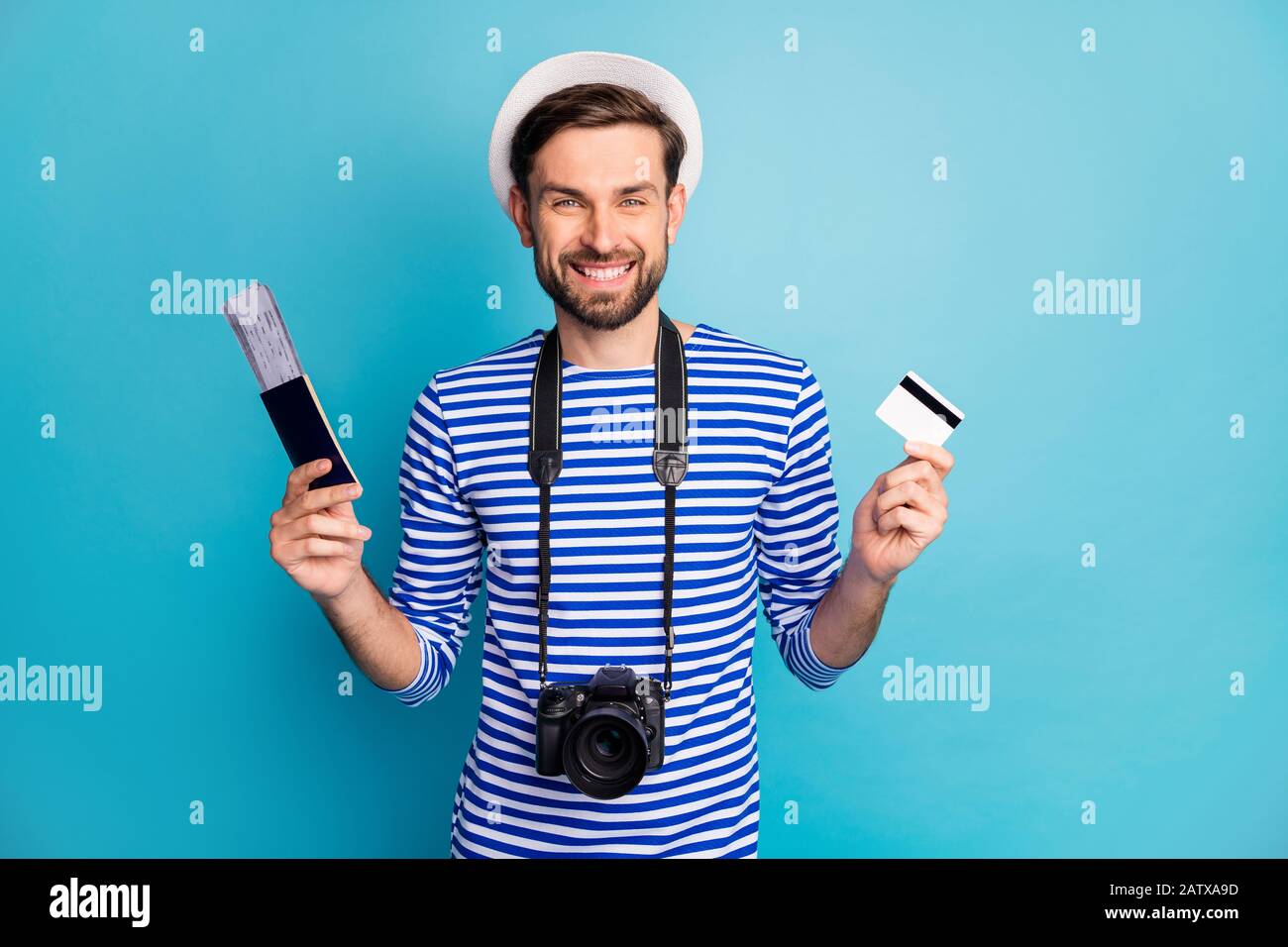 Foto des attraktiven Kerlfotografen halten professionelle Digitalkamera-Reisende kaufen Tickets mit Hilfe von Kreditkarte tragen gestreifte Seemannshirt Weste Kappe Stockfoto