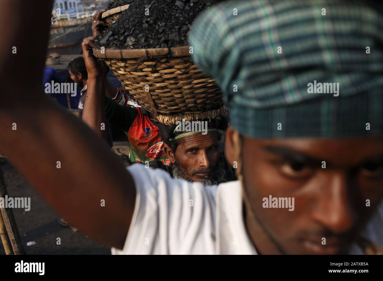 Dhaka, Bangladesch. Februar 2020. Arbeiter entladen Kohle von einem Kahn in einem Korb auf dem Kopf am Ufer des Turag River. Kredit: MD Mehedi Hasan/ZUMA Wire/Alamy Live News Stockfoto