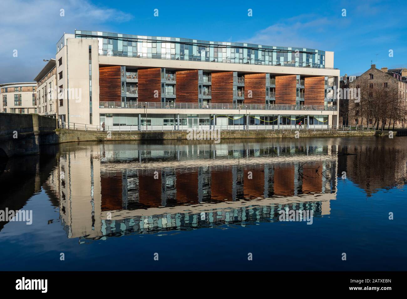Moderner Apartmentblock am Sandport Place spiegelt sich im Wasser von Leith in Leith, Edinburgh, Schottland, Großbritannien wider Stockfoto