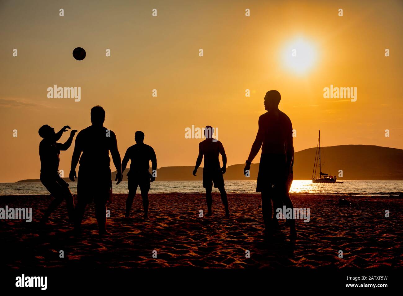 Silhouetten von Menschen, die am Strand in Elafonissos, Peloponnes, Griechenland Fußball spielen Stockfoto