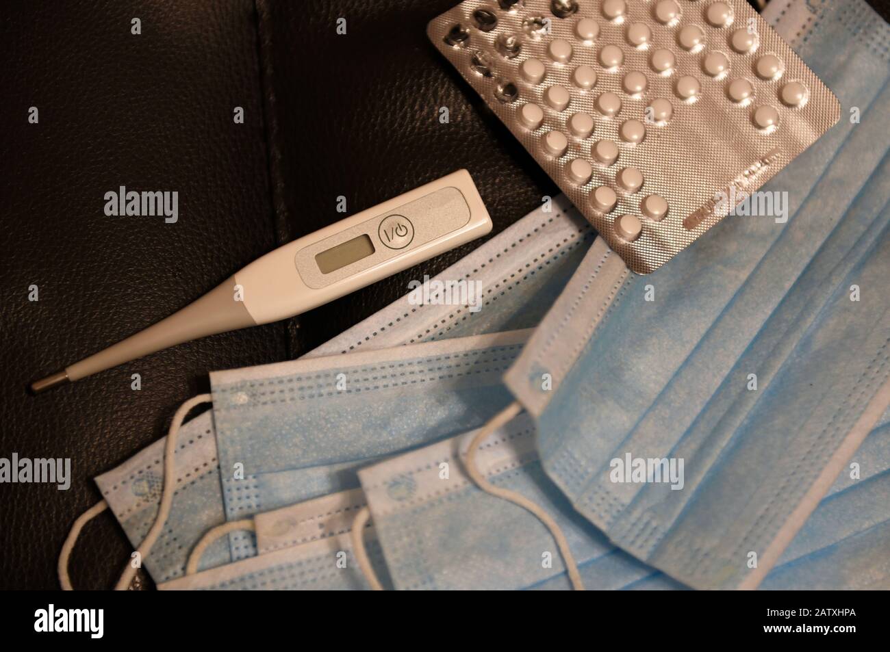 Medikamente, Thermometer und medizinische Masken liegen auf dem Tisch Stockfoto