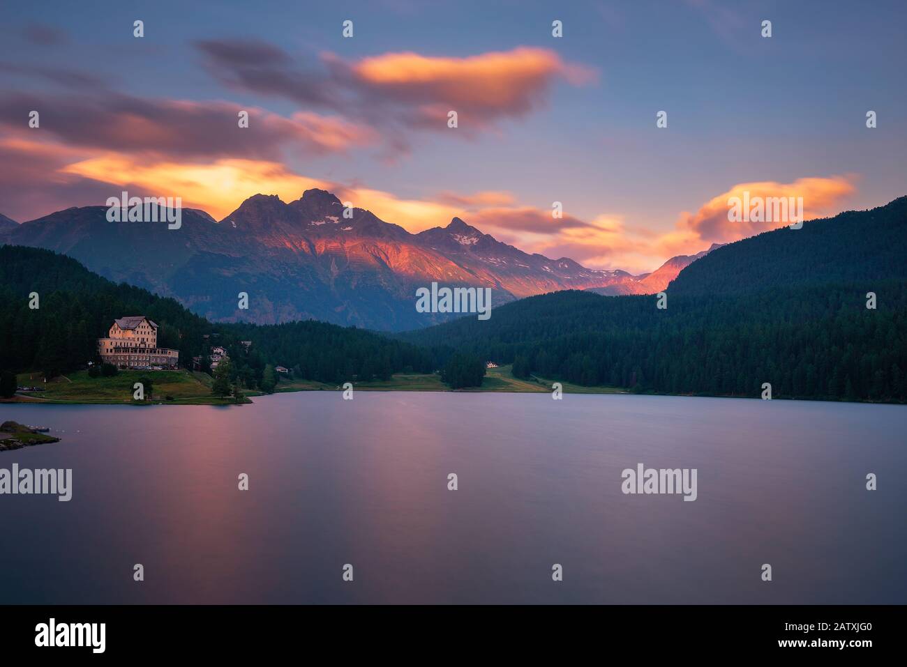Sonnenuntergang über dem St. Moritzersee mit Schweizer Alpen und einem Berghotel Stockfoto