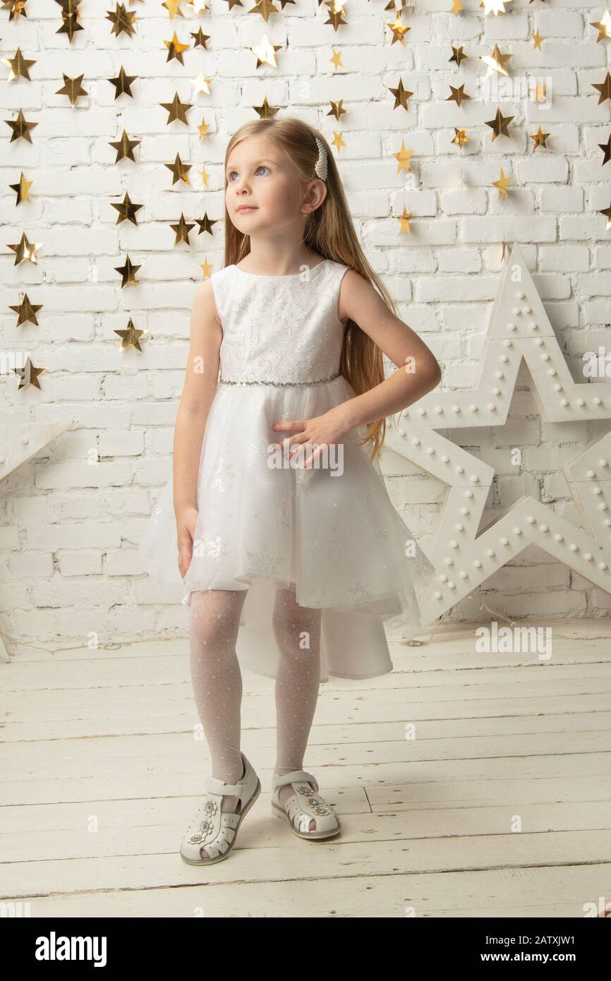 Vertikal elegantes Kind in einem weißen Kleid. Kleines Mädchen Modell  Stockfotografie - Alamy