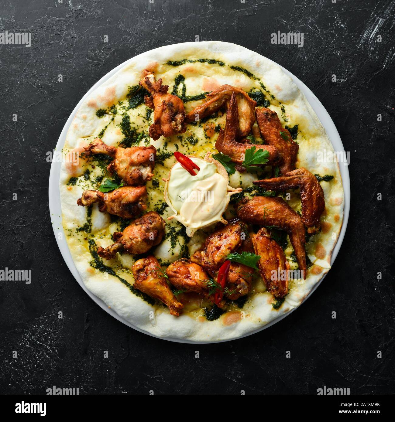 Gegrillte Hühnerflügel. Pizza mit Hühnerflügeln. Traditionelle italienische Küche. Draufsicht. Freier Speicherplatz. Stockfoto