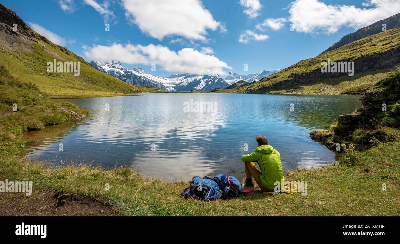 Wanderer mit Rucksack am Bachalpsee, Gipfel Schreckhorn und Finsteraarhorn, Grindelwald, Berner Oberland, Schweiz Stockfoto