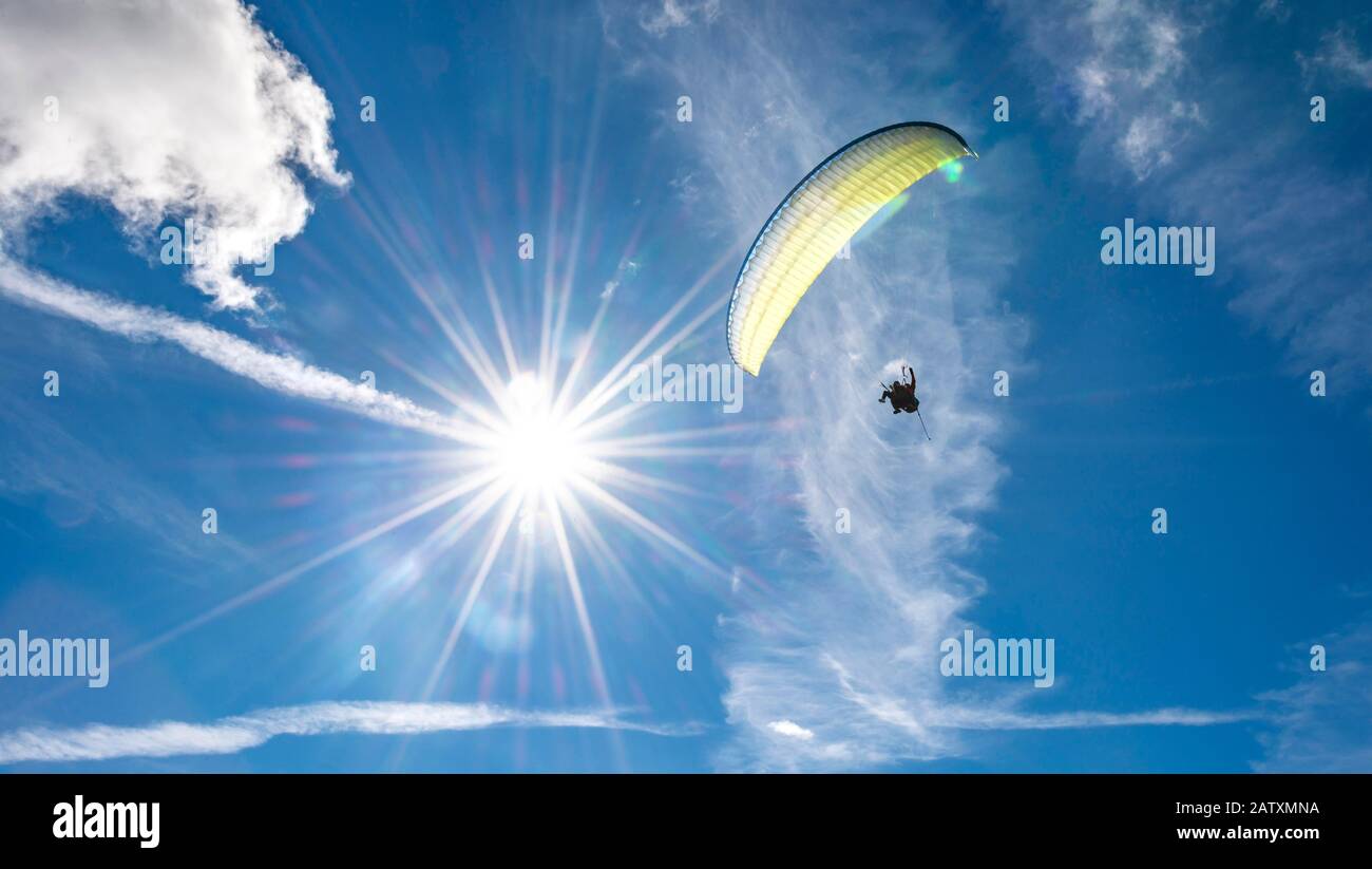 Gleitschirmflieger am Himmel, Sonnenstrahlen, Grindelwald, Bern, Schweiz Stockfoto