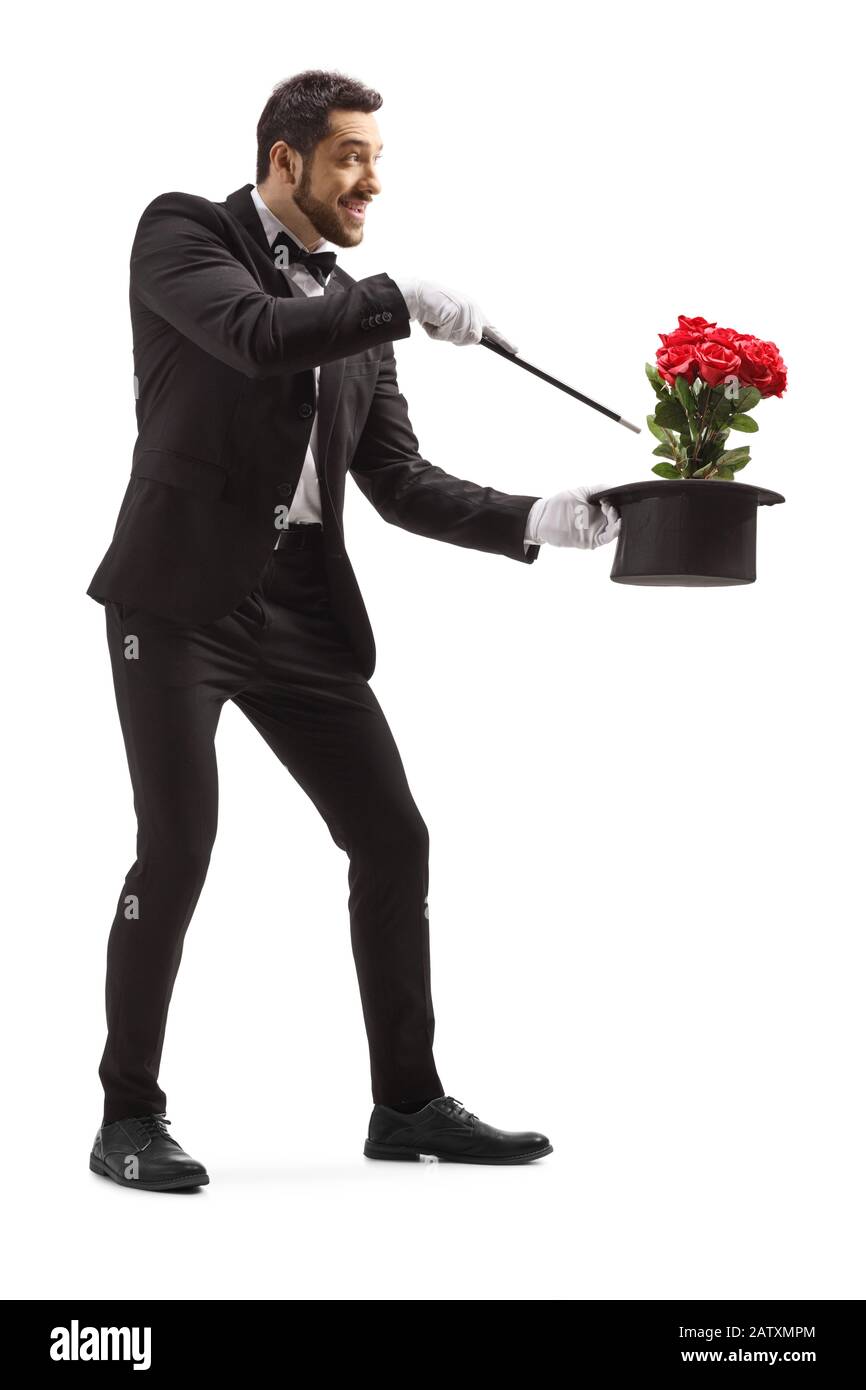 Schuss eines Zauberers in voller Länge, der einen Trick mit Hut und roten Rosen ausführt, der auf weißem Hintergrund isoliert ist Stockfoto