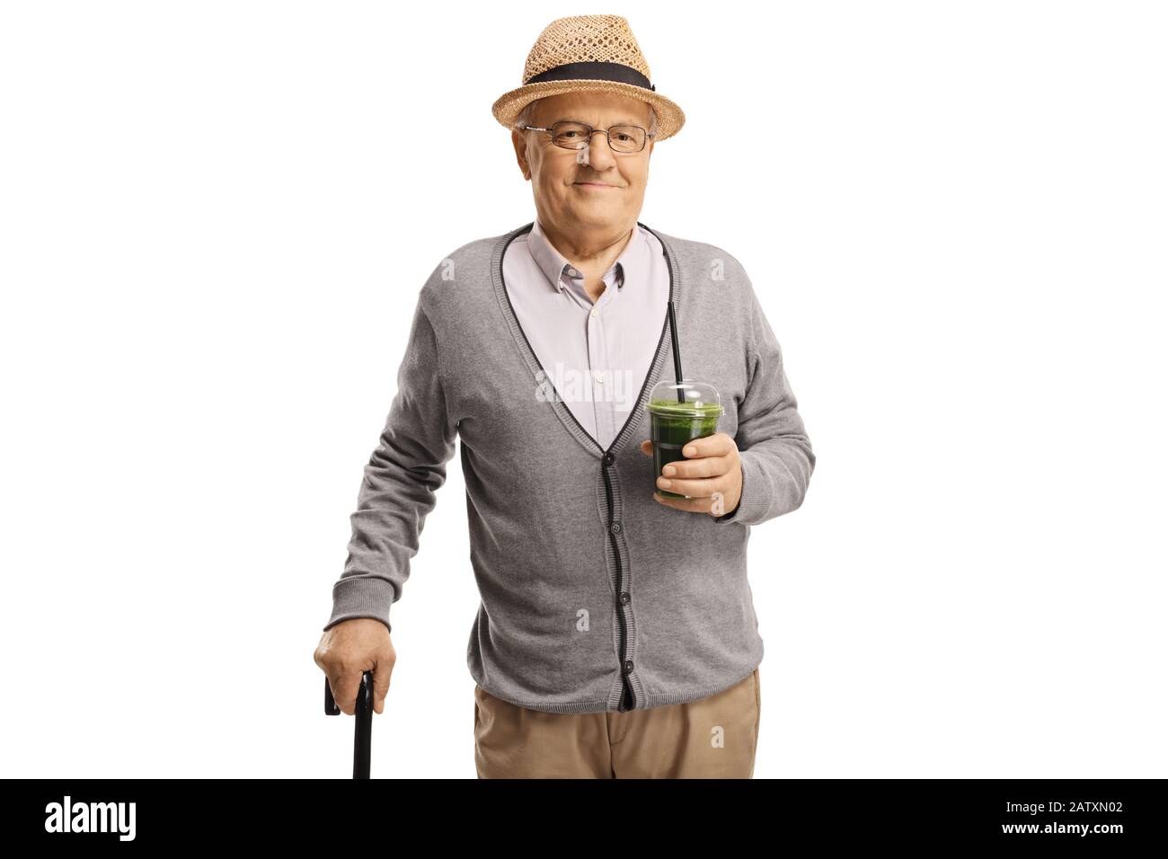 Senior Gentleman mit einem Gehstock, der einen gesunden grünen Smoothie hält, der auf weißem Hintergrund isoliert ist Stockfoto