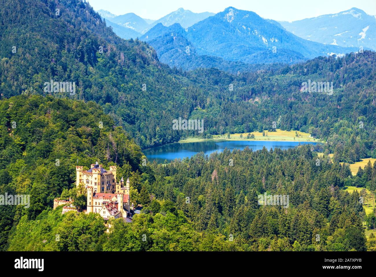 Schloss Hohenschwangau in Alpen, Bayern, Deutschland. Panoramasicht auf die schöne Burg mit Schwansee. Alpine Berglandschaft im Sommer. Pano Stockfoto