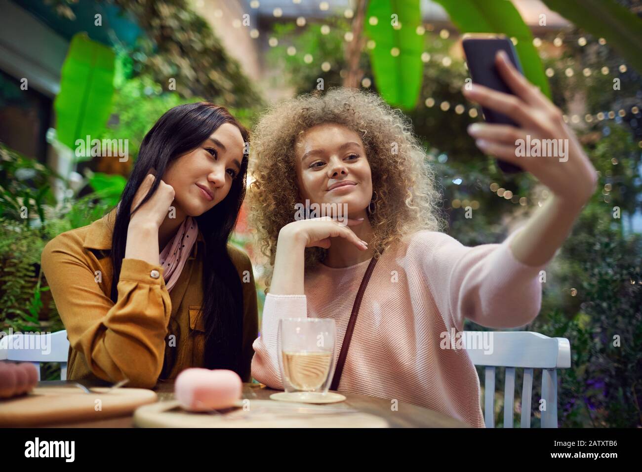 Zwei schöne Freunde, die selfie Portrait auf dem Handy machen, während sie im Café sitzen Stockfoto