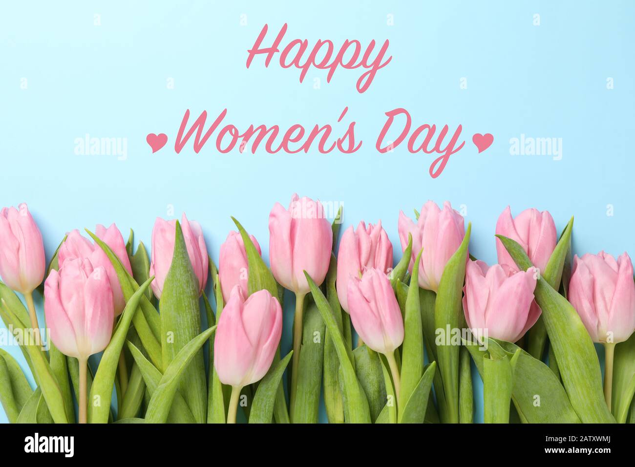 Aufschrift Happy Women's Day auf blauem Hintergrund mit Tulpen, Draufsicht Stockfoto