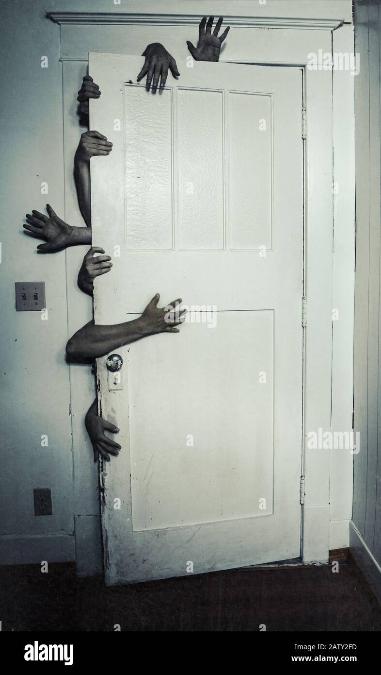Gruseliges Bild von mehreren Händen, die eine Tür öffnen Stockfoto