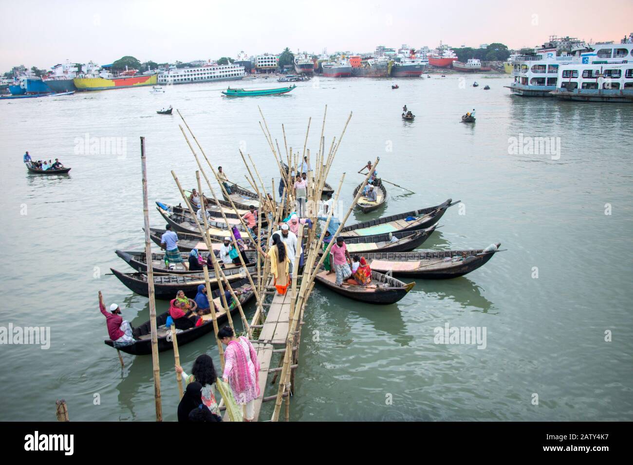 Menschen, die vom Holzboot am Bootsterminal im Burigonga-Fluss abfahren, um den Fluss in Sadarghat dhaka bangladesh zu überqueren Stockfoto