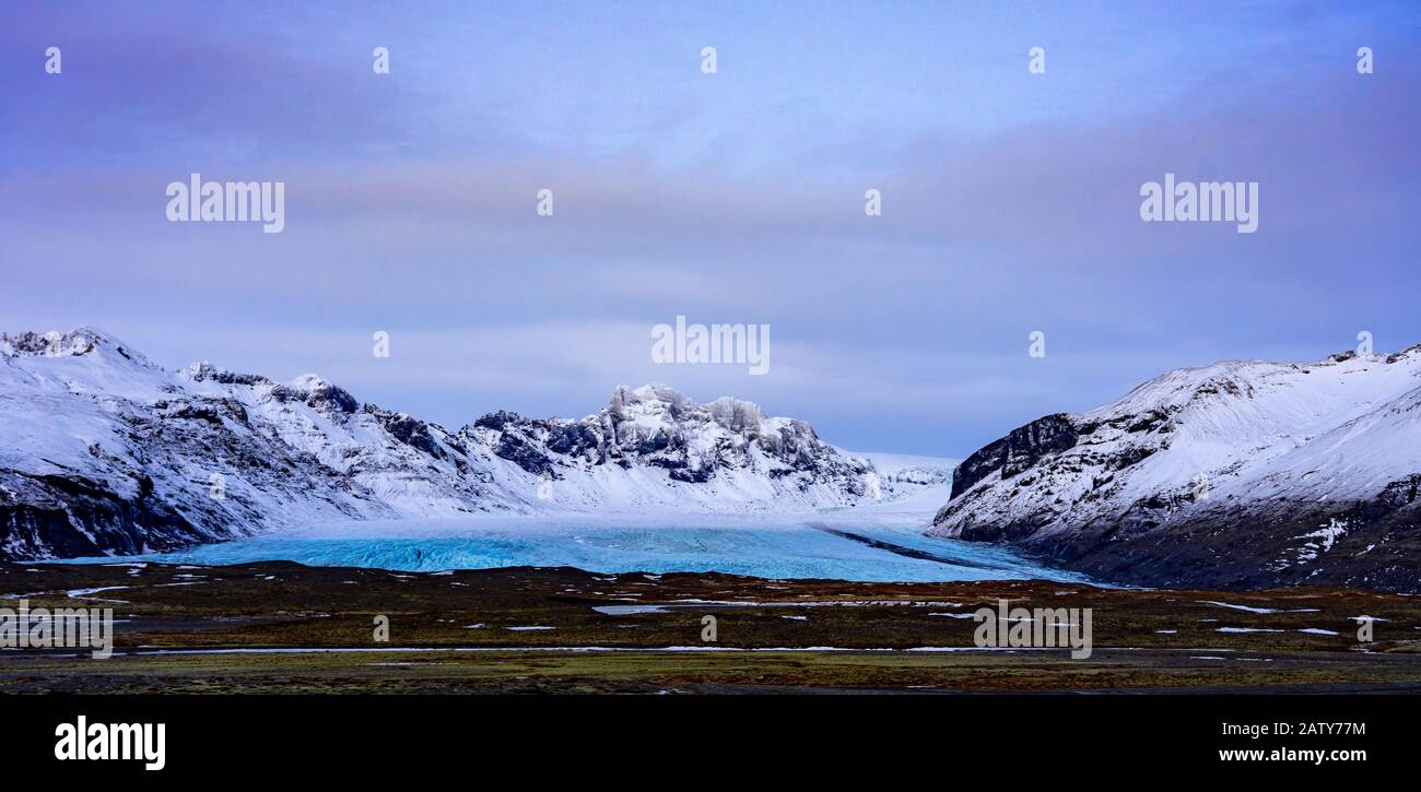 Berge in Island mit blauem Gletscher dazwischen Stockfoto