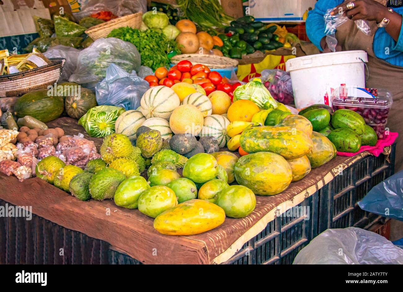 Obstmarkt auf der Straße, auf dem Einheimische tropische Früchte wie Melonen, Mangos, Orangen, Zitronen und mehr genießen. Es befindet sich im Senegal, in der Nähe von Dakar. Stockfoto