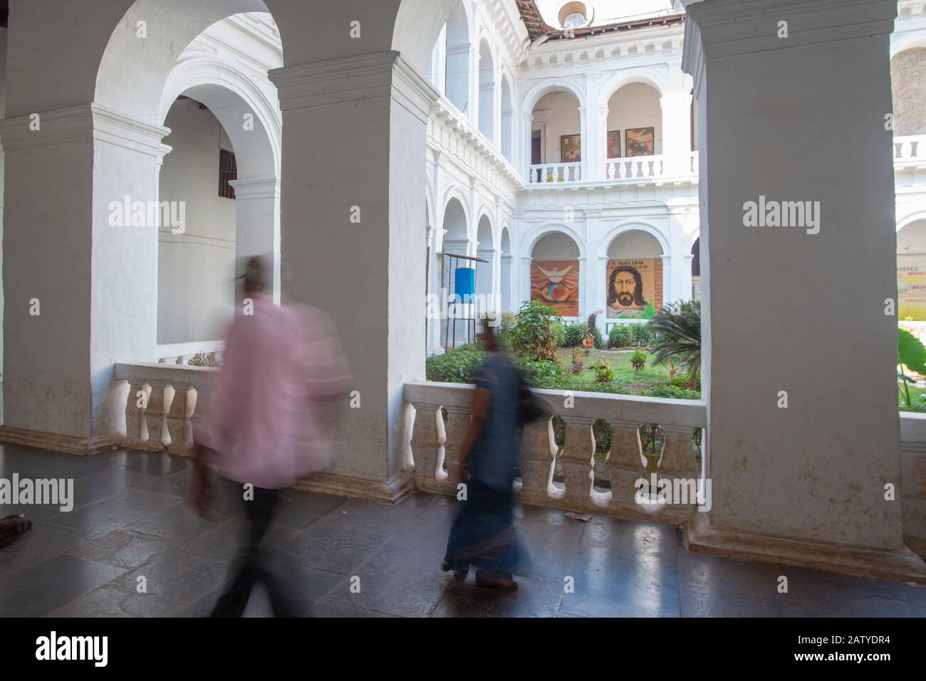 Old Goa, Indien - 26. Februar 2018: Innenansicht des Kreuzgangs der Bom-Jesus-Basilika mit zwei nicht erkennbaren Besuchern Stockfoto