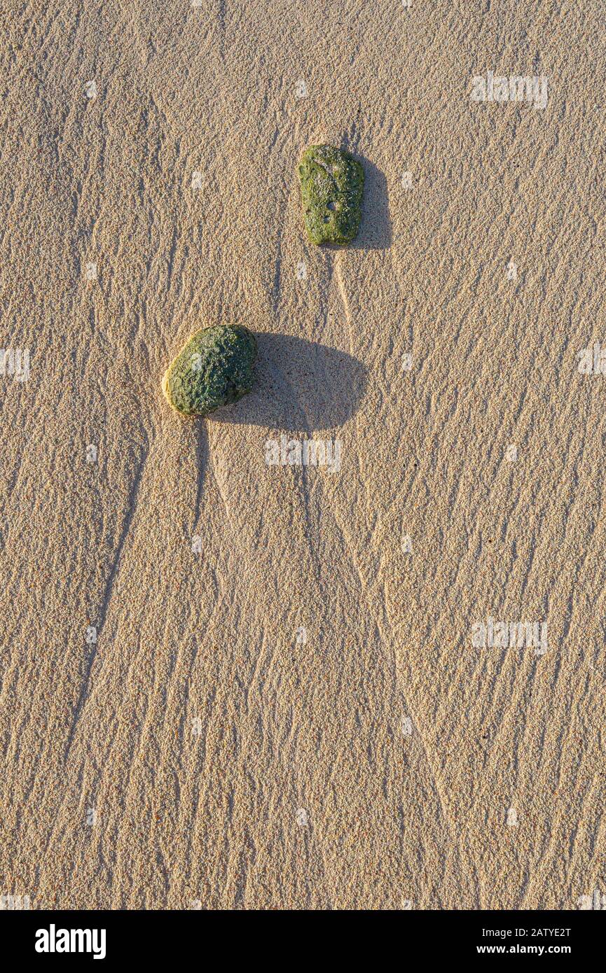 Muster im Sandstrand von Wellen und zwei Felsen Stockfoto
