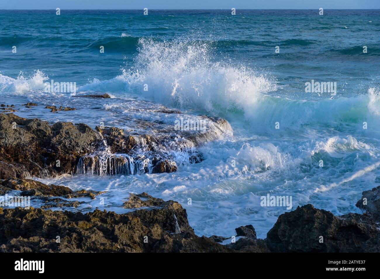 Wellen, die in felsige Ufer abstürzen, liegen in den Löchern auf Grand Cayman Island Stockfoto