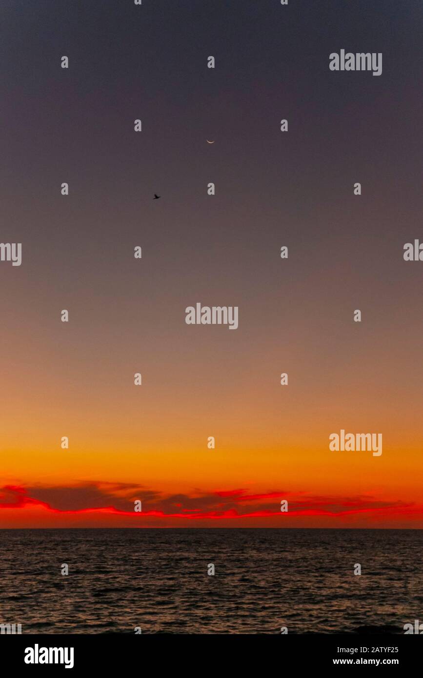 Ein Halbmond und Sterne sind zu sehen, wenn die Sonne über die Banderas-Bucht in Puerto Vallarta, Mexiko untergeht. Stockfoto