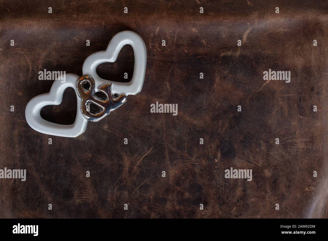 Valentinstag, zwei weiße Herzen und Du Symbole auf Lederhintergrund. Ansicht mit hohem Winkel, Platz für Text. Stockfoto