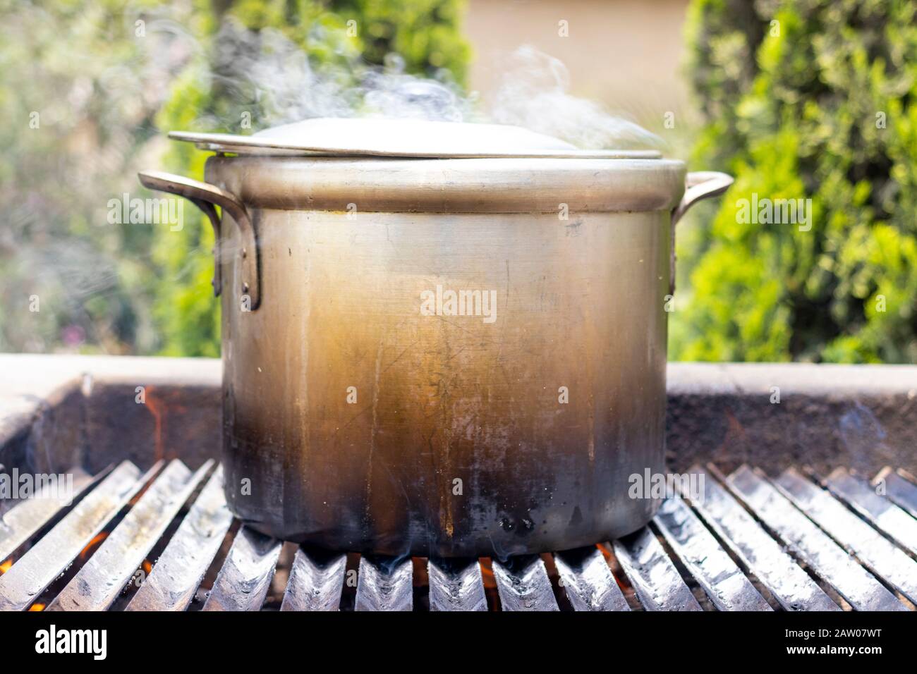 Zubereitung von Suppe in einem Topf, in der Natur. Suppe durch das Holzfeuer kochen Stockfoto