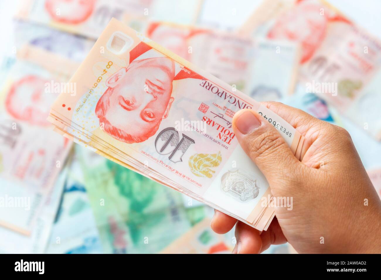 Hand mit Singapur-Dollar-Banknote, Hintergrund Stockfoto