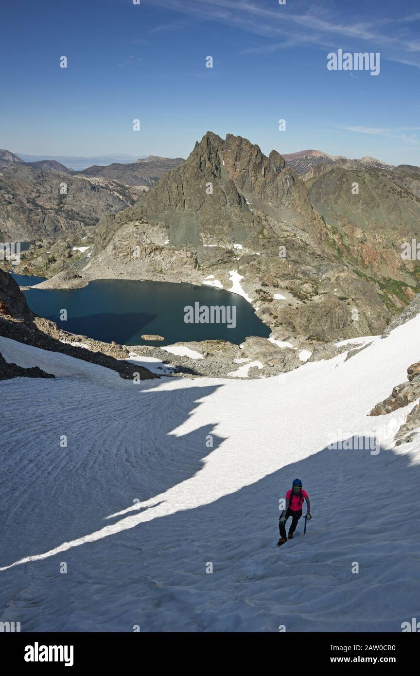 Frau, die auf einem steilen Schneefeld in der Minaret-Reihe der Sierra Nevada Mountains klettert Stockfoto