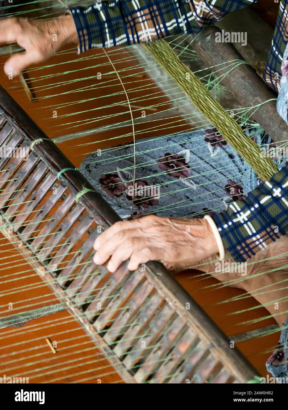 Traditionelles Weben von Matten aus einem Schilf, das entlang des Mekong Flusses in Vietnam wächst Stockfoto
