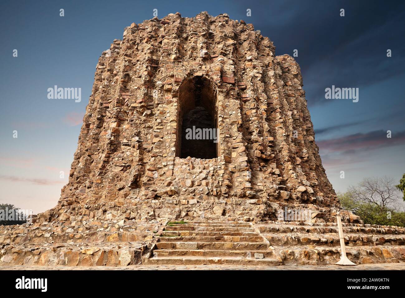 Großer ruinierter Turm im Qutub Minar Komplex in Neu-Delhi, Indien bei lila Sonnenuntergang Stockfoto