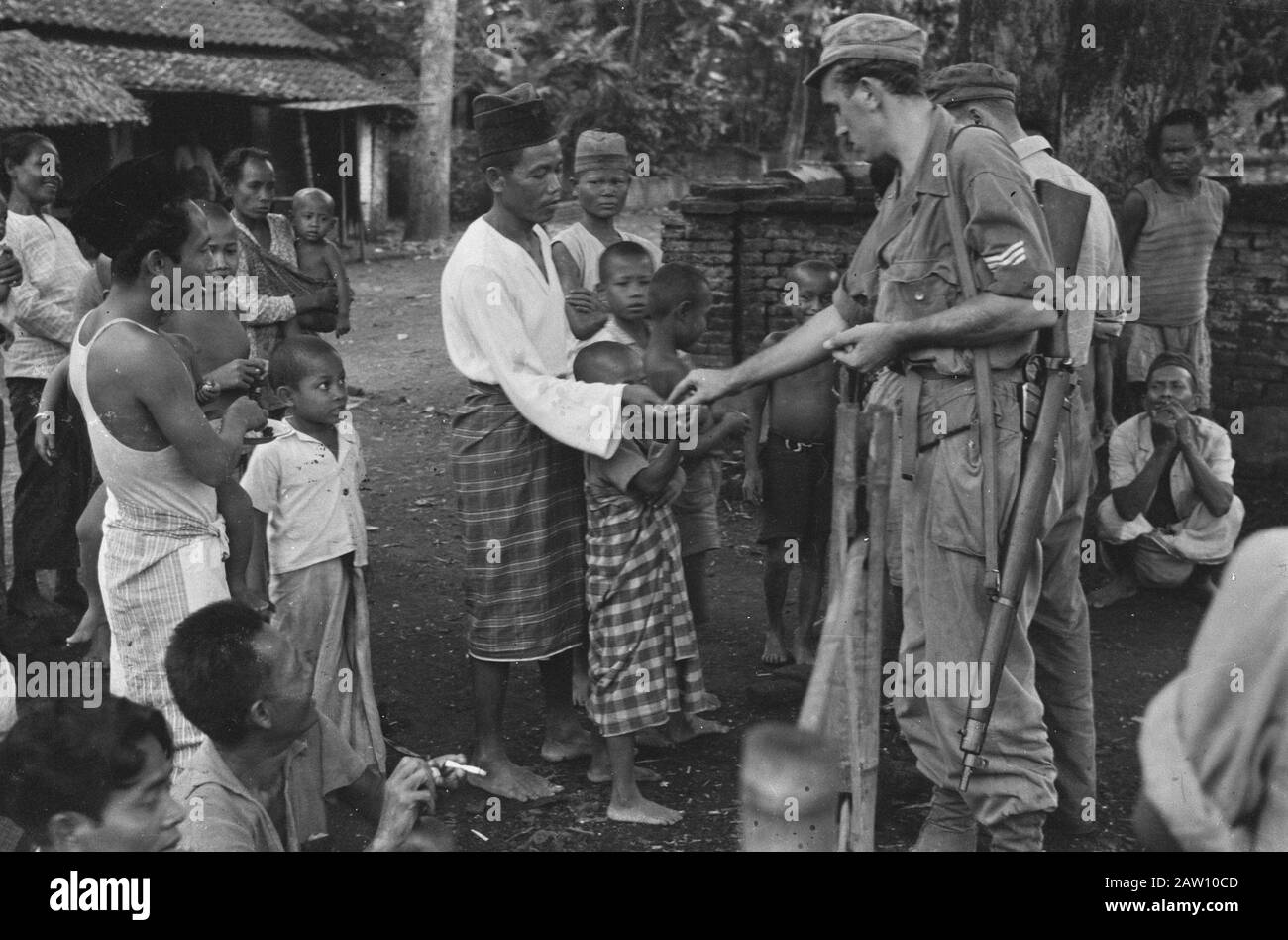 Dörfer rund um Cheribon Umwelt Cheribon. Wenn der Funkwagen ins Dorf kommt, wird die Bevölkerung am Rande zurückschrecken, aber auch dort erreichten sie die Stimme ihrer eigenen Landsleute, die die holländischen Soldaten von Djocja einflößt fürchten, verschwinden mit ihnen. Dann tauchen sie auf und sie begrüßen die Soldaten, die wiederum geben, was sie geben, Zigaretten und Snacks, die dankbar angenommen werden Datum: 29. Oktober 1947 Ort: Cirebon, Indonesien, Niederländisch-Ostindien Stockfoto