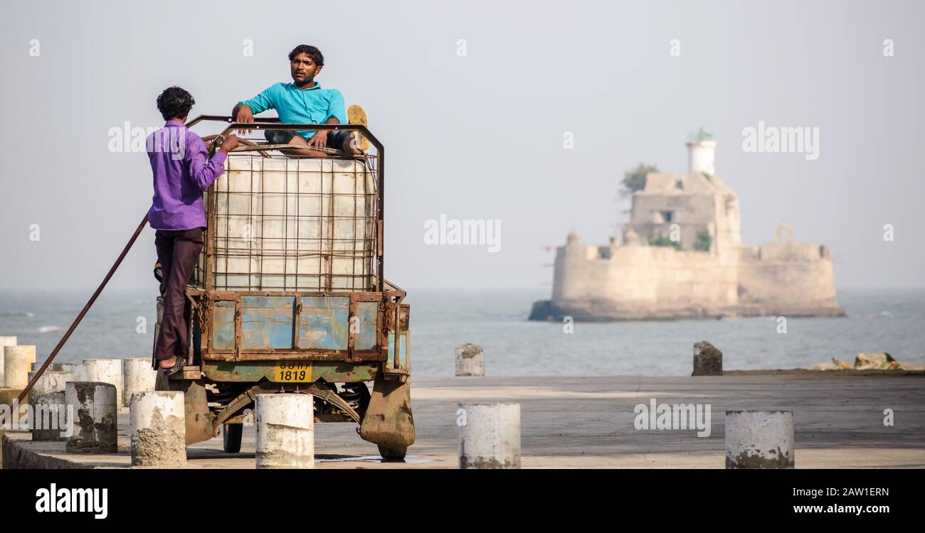 DIU, Indien - Dezember 2018: Zwei Fischer sitzen auf einem mit Eis beladenen Fahrzeug, um sich während eines heißen Tages auf der Insel Diu abzukühlen. Stockfoto