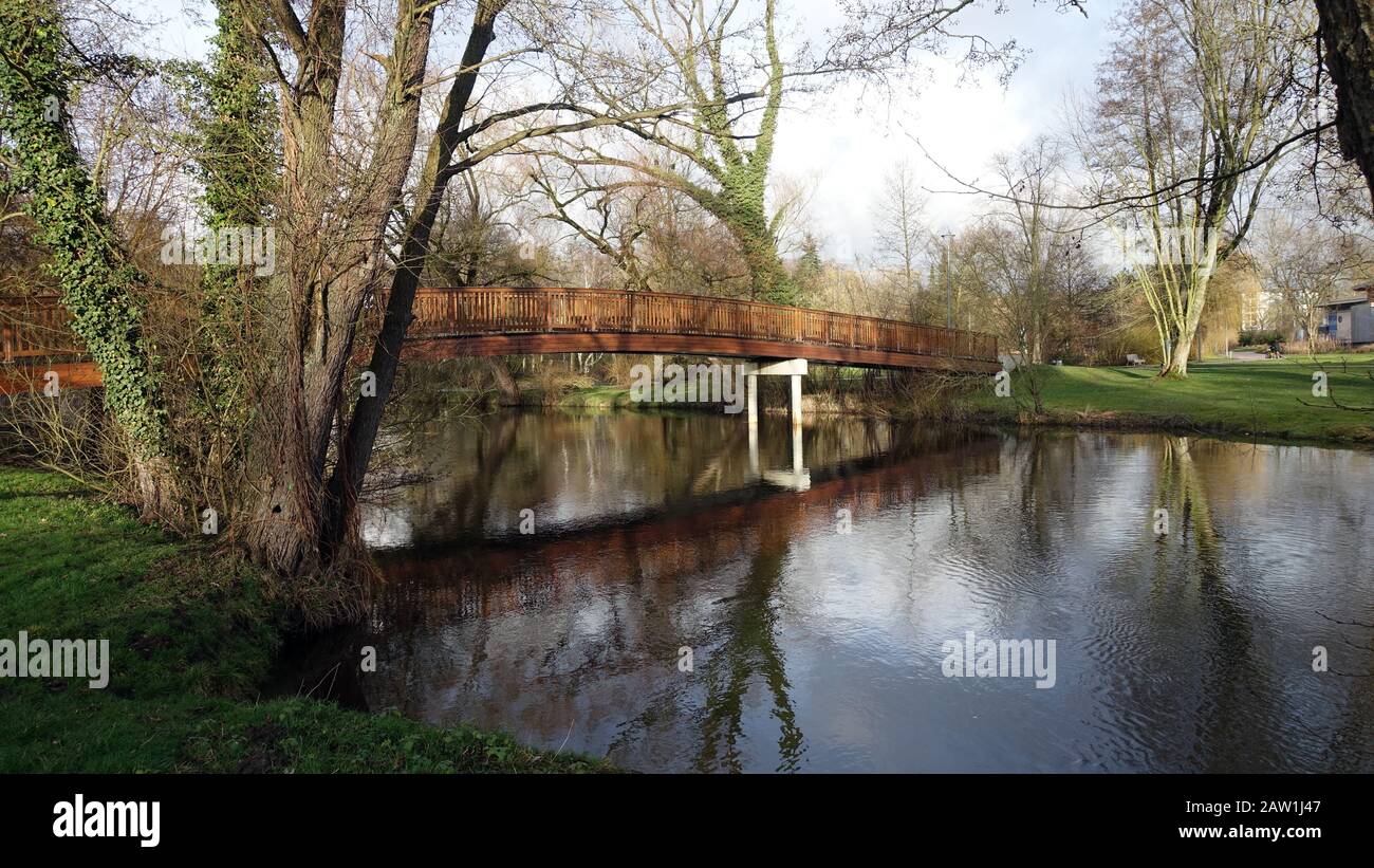 Fussgängerbrücke aus Holz über die Ilmenau zum Kurpark, Bad Bevensen, Niedersachsen, Deutschland Stockfoto