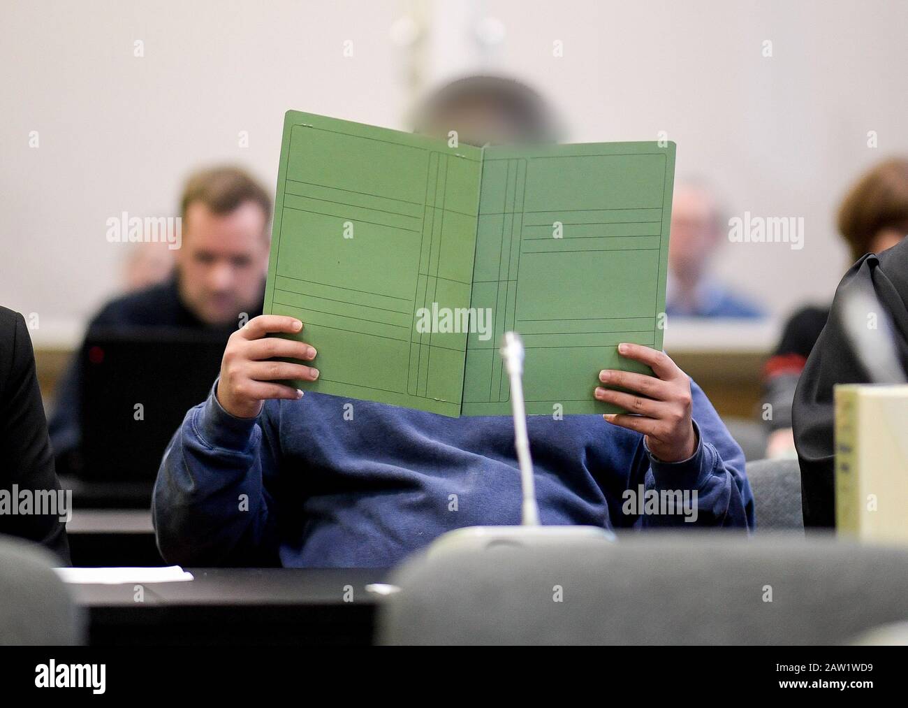 06. Februar 2020, Hamburg: Ein Angeklagter deckt sich während des Prozesses für die Erschießung eines Rocker-Chefs in St. Pauli mit einer Aktenmappe. Foto: Axel Heimken / dpa Stockfoto