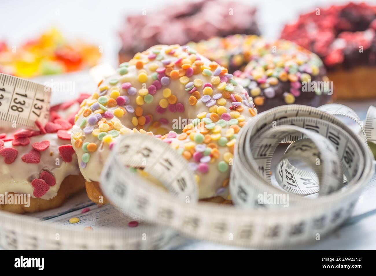 Süß glasierte Donuts und Maßband auf dem Tisch. Stockfoto