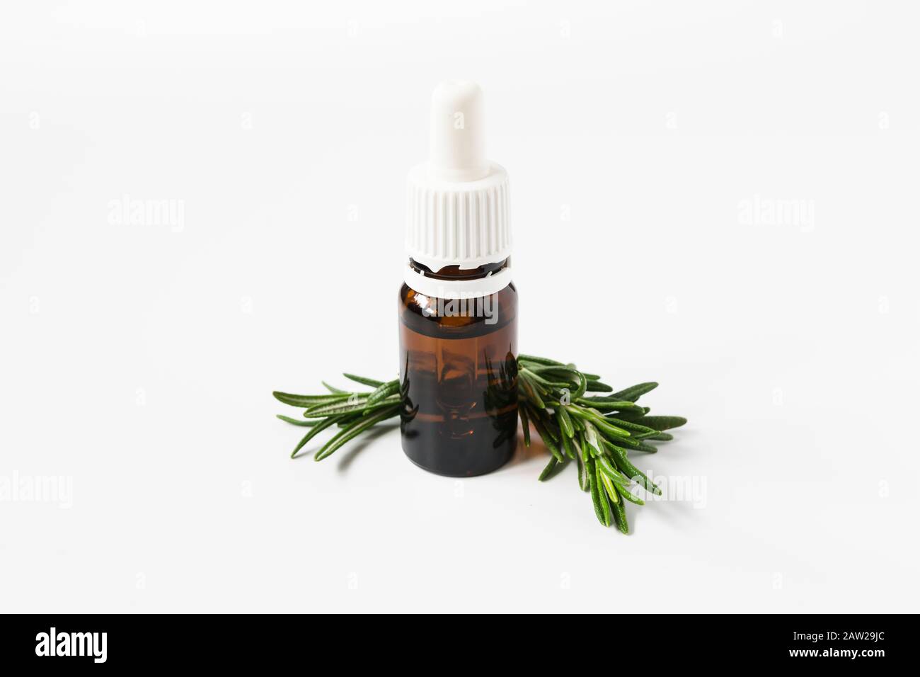 Isolierte Glasflasche mit aromatischem Öl und Rosmarinsprengel auf weißem Hintergrund Stockfoto