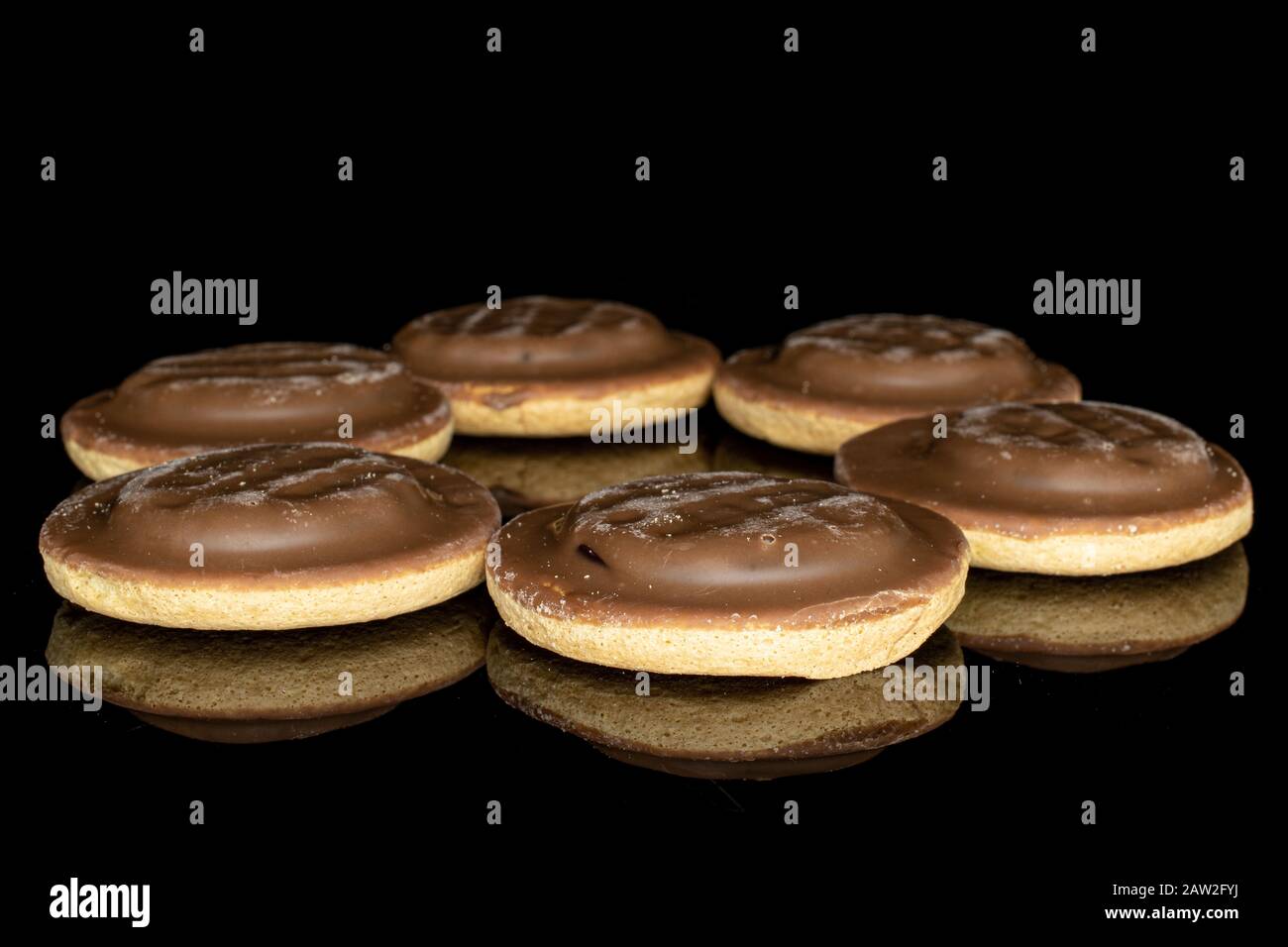Gruppe von sechs ganzen Schokoladenbiskuit-Ring isoliert auf schwarzem Glas Stockfoto