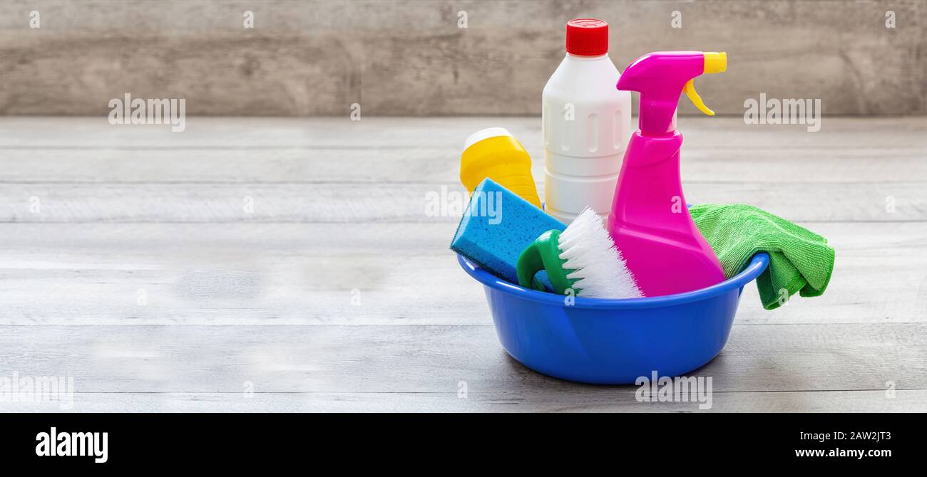 Reinigungsmittel auf dem Boden, Innenhintergrund. Chemische Waschmittelflaschen in einer blauen Schüssel. Hausrat- oder betriebswirtschaftliche Sanitäranlagen Stockfoto