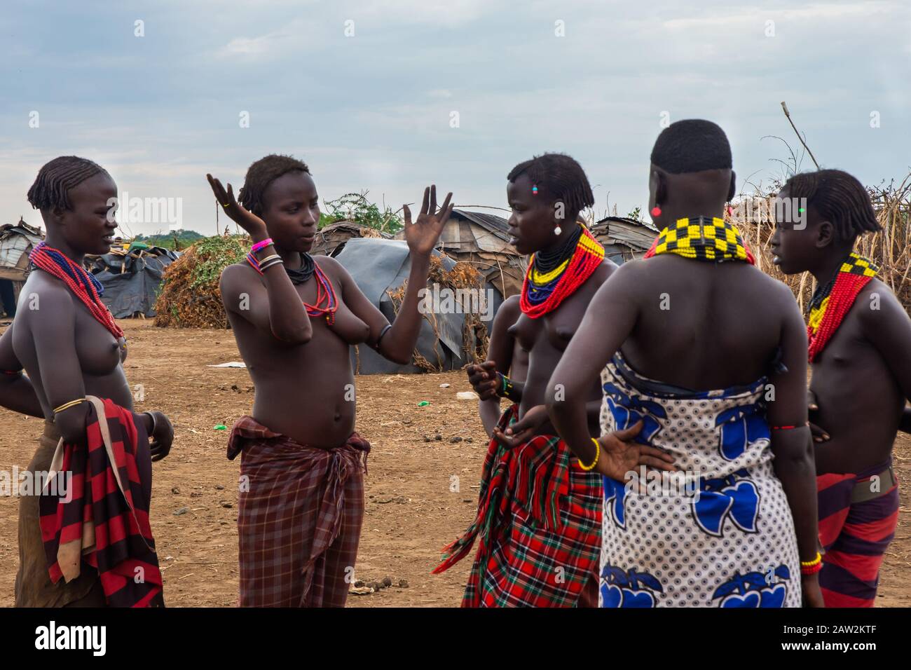 Omorate, Äthiopien - November 2018: Junge Männer und Frauen tragen traditionelle Stammeskleidung und Halsketten, die miteinander sprechen. Omo-Tal Stockfoto