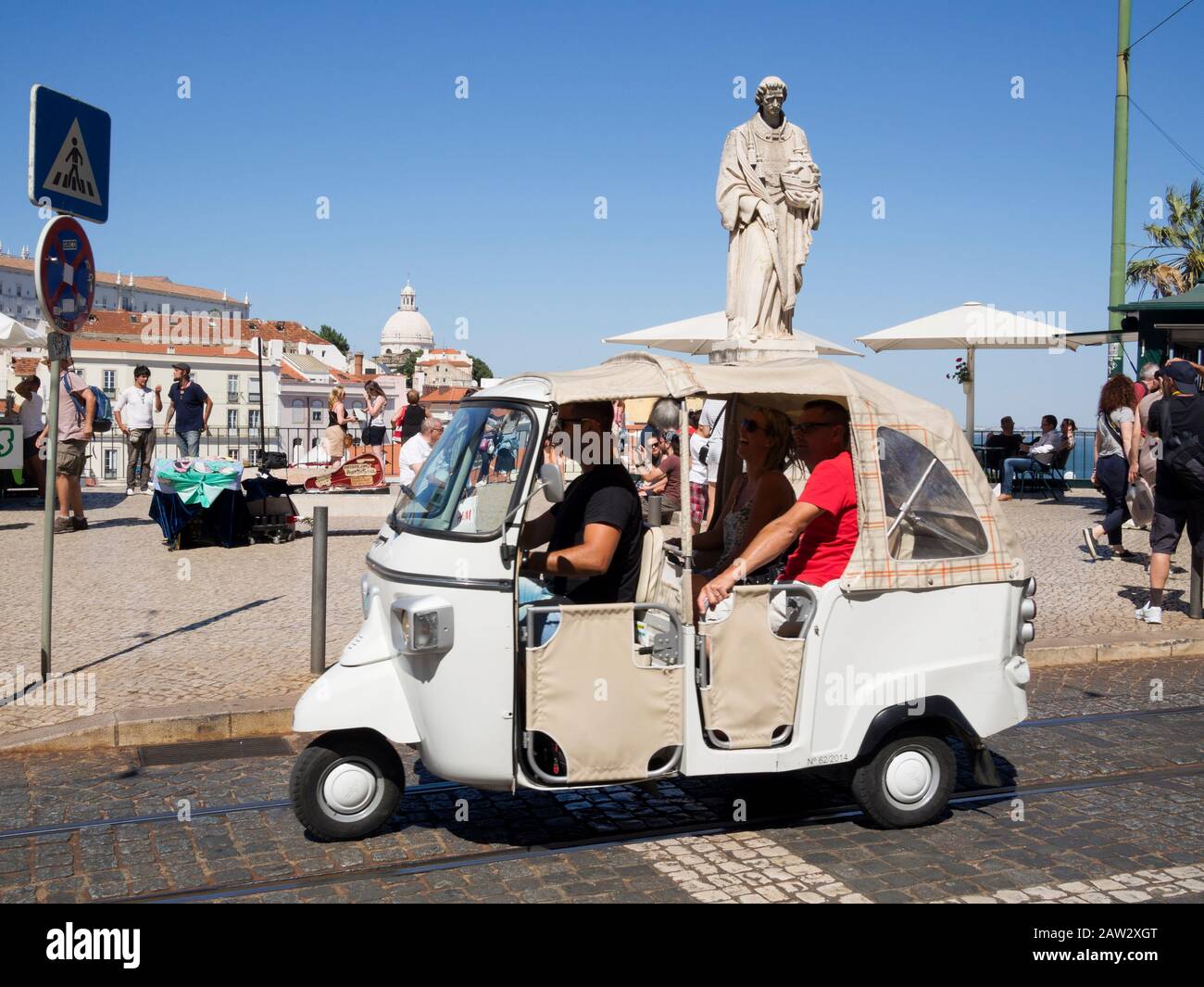 Touristen, die ein Tuktuk-Fahrzeug für Besichtigungstouren in Lissabon, Portugal, fahren Stockfoto