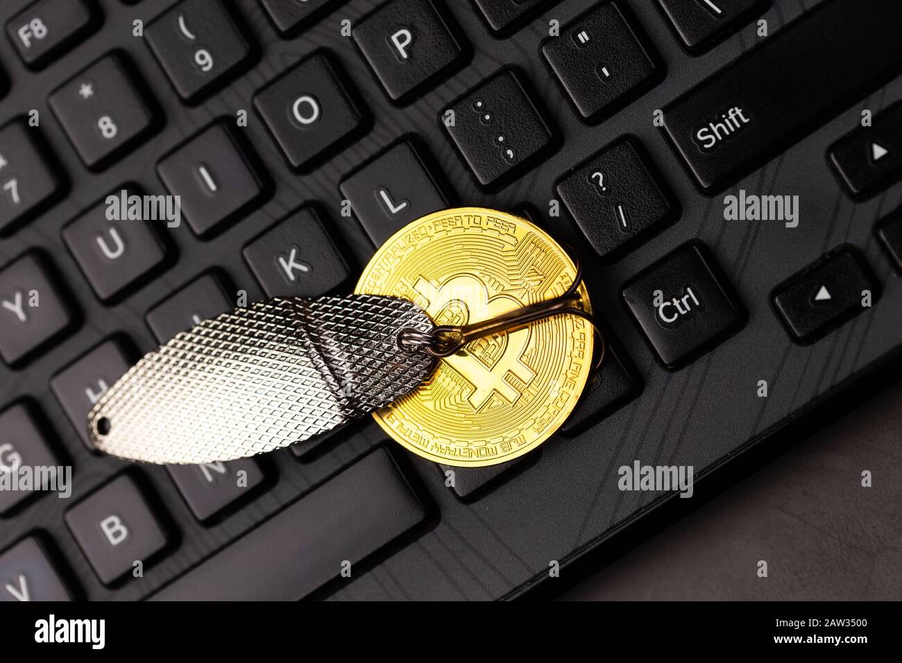 Bitcoin an einem Haken über der Tastatur. Konzept, Geld zu fangen, Geldschrecken, Kryptologie-Betrug Stockfoto