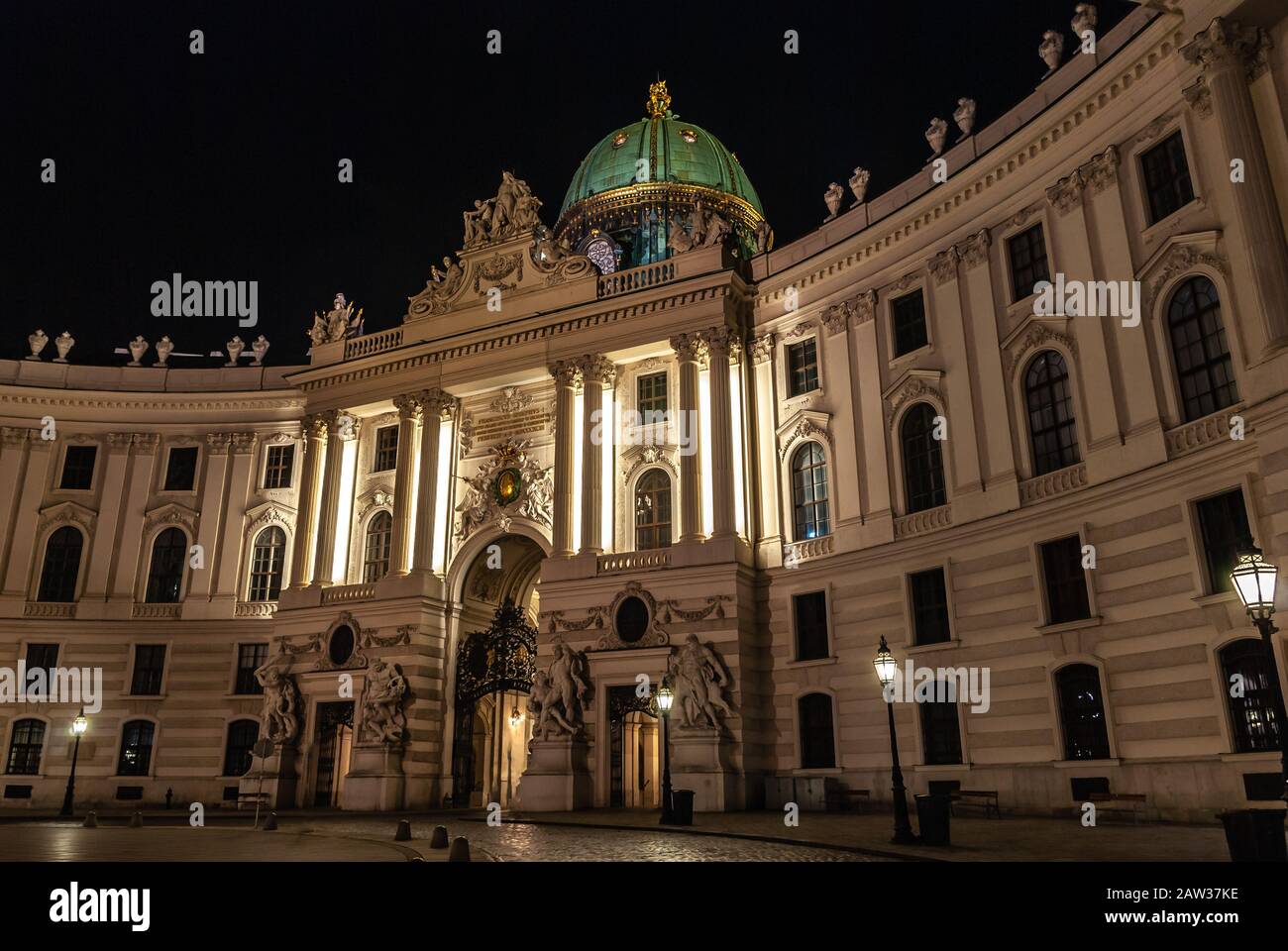 Wien, Österreich. Hauptzugang zum Schloss Hofburg, nachts vom Michaelerplatz aus gesehen, Weitblick in der Abenddämmerung, Wahrzeichen des Habsburger Imperiums in Wien Stockfoto