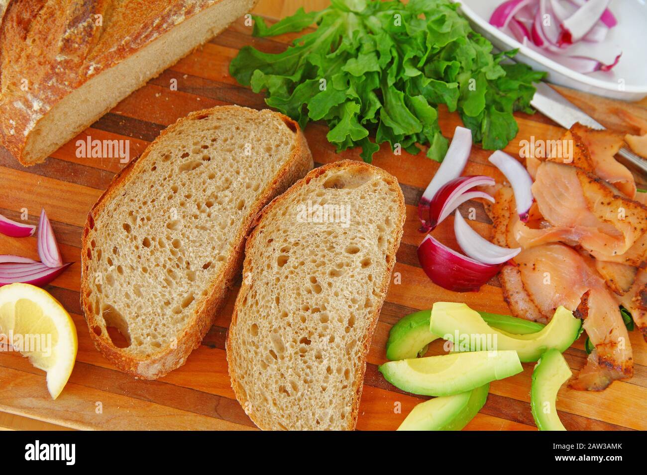 Ein geräucherter Lachs Sandwich mit Salat, Zwiebeln und Avocado auf Artisan Brot Stockfoto