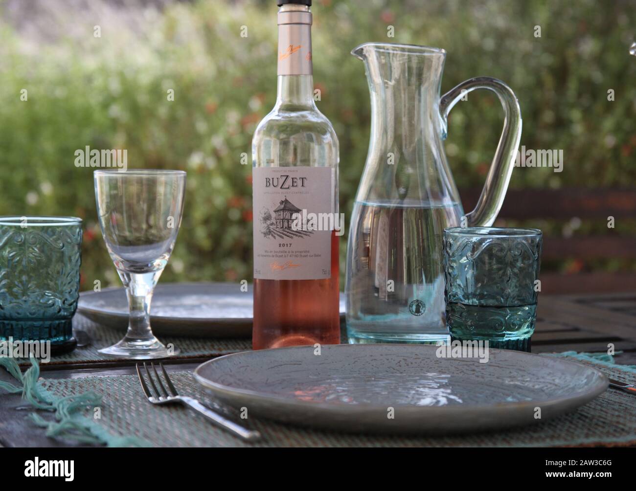 Terrassentisch zum Mittagessen in Frankreich mit Weinflasche und Gläser. Stockfoto