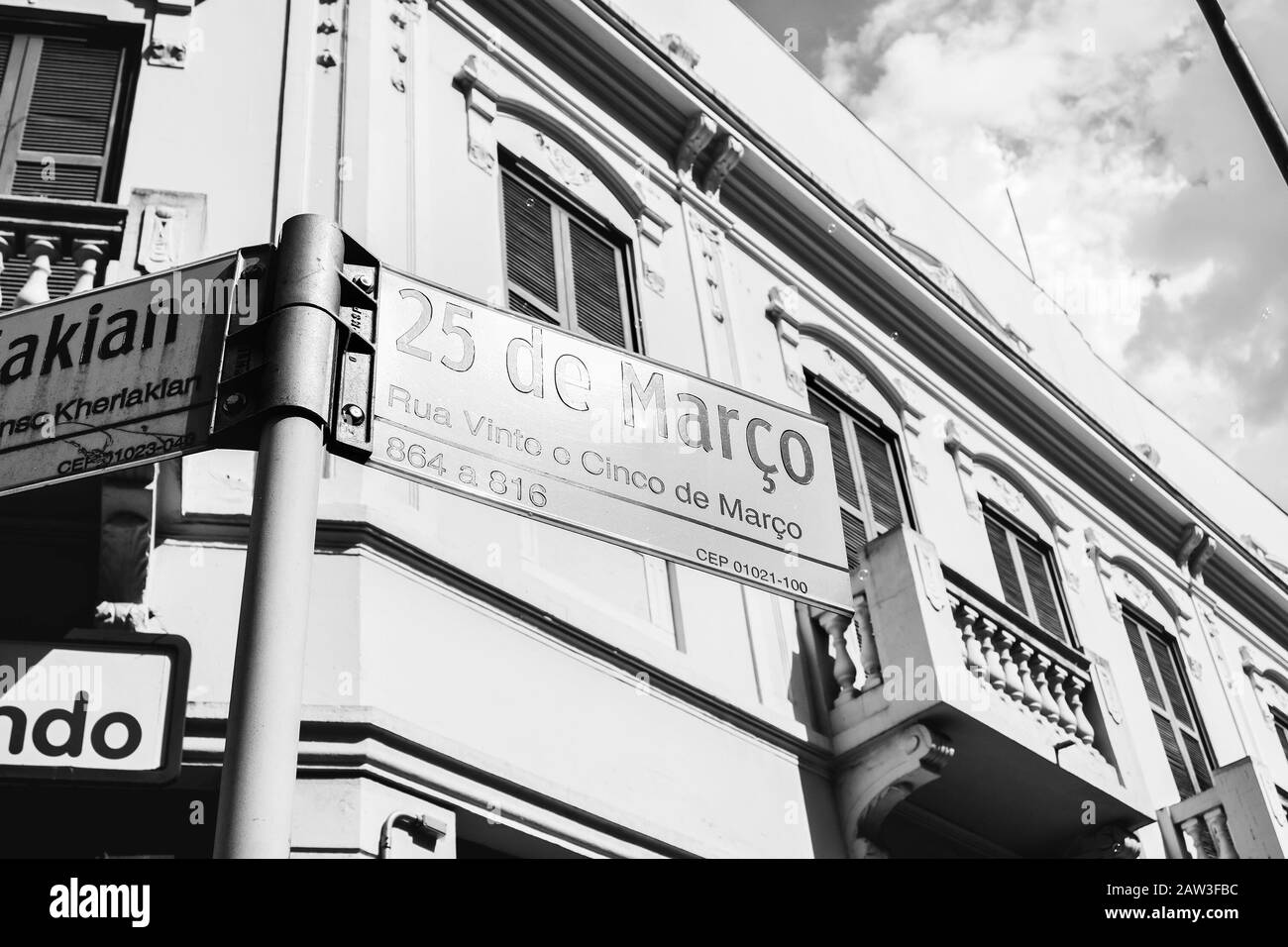 Sao Paulo SP, Brasilien - 22. November 2019: Straßenschild der 25. März Straße, Straße des beliebten Handels. Schwarzweißfoto. Stockfoto