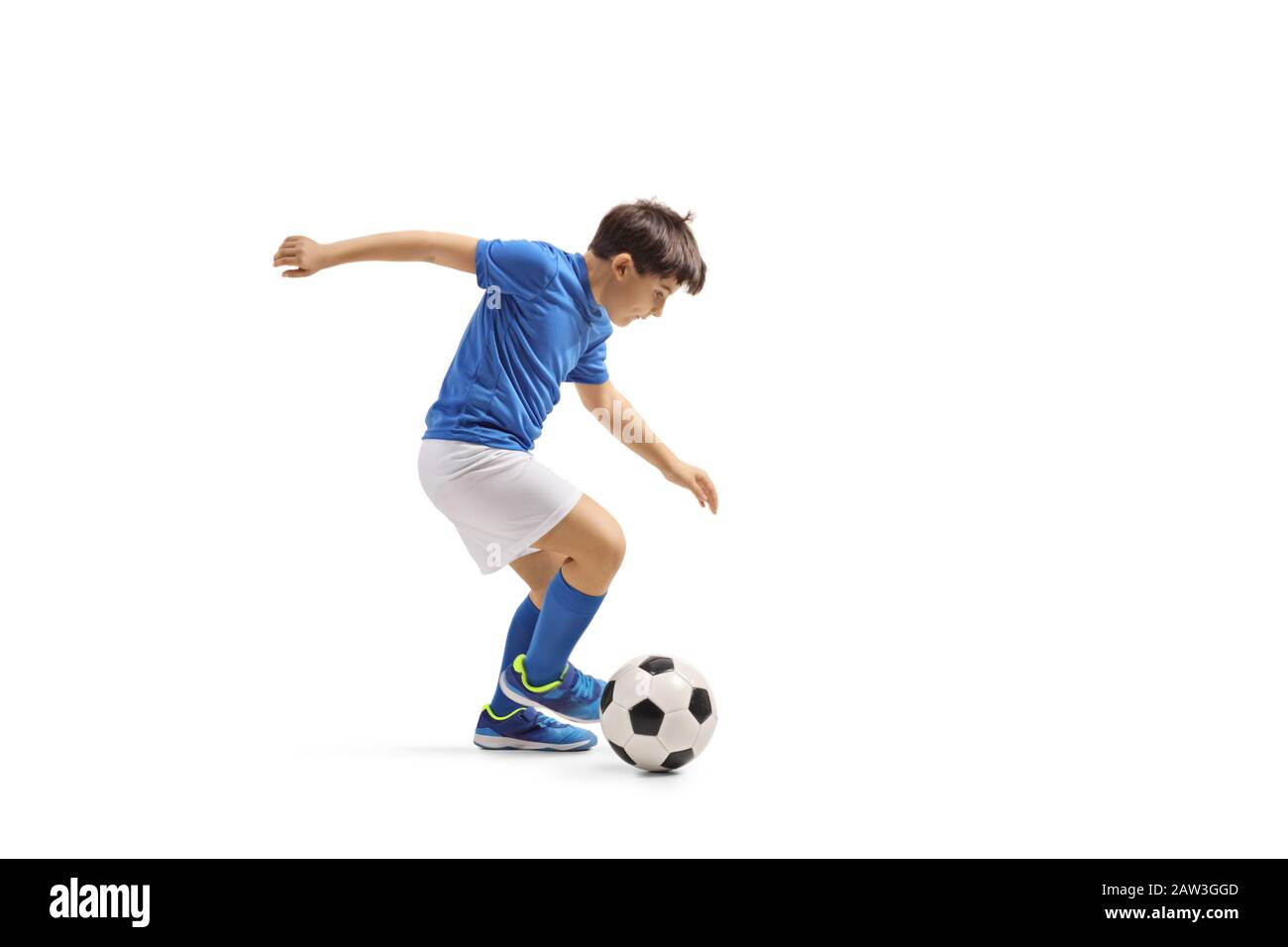 Lange Aufnahme eines Jungen in einem blauen Trikot, der Fußball spielt, isoliert auf weißem Hintergrund Stockfoto