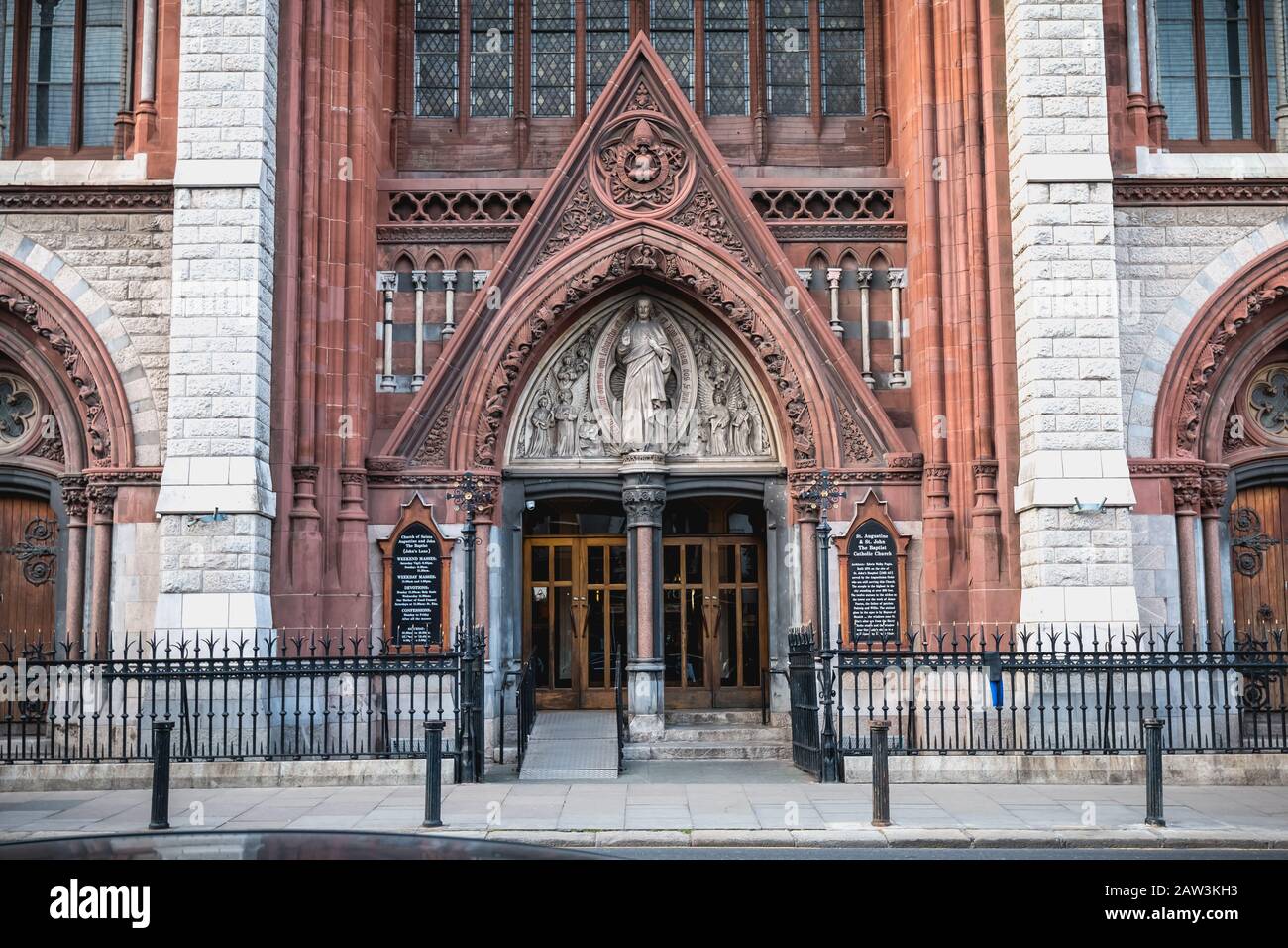 Dublin, Irland - 13. Februar 2019: Straßenatmosphäre und Architektur der katholischen Kirche St. Augustine und St. Johannes Der Täufer, die die Menschen besuchen Stockfoto