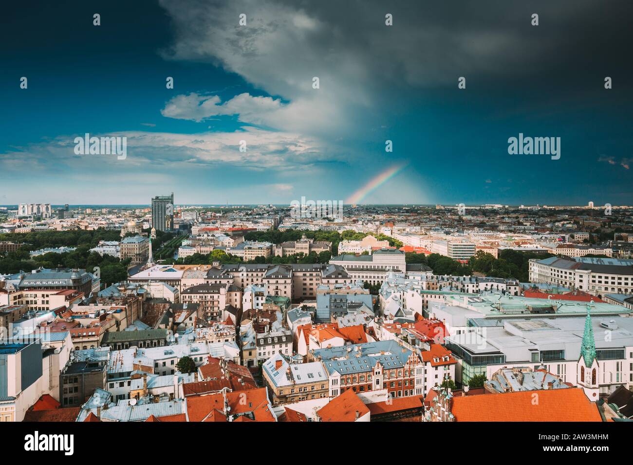 Riga, Lettland. Regenbogen Bei Sommerregen Über Rigaer Stadtbild Skyline. Stockfoto